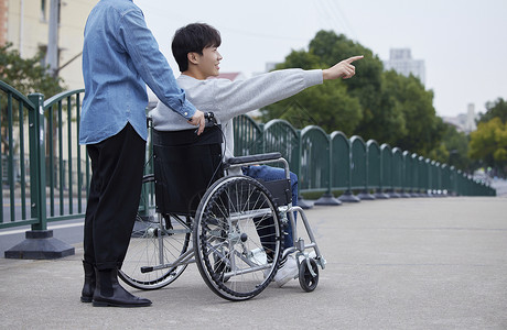 世界双相情感障碍日家人陪伴坐轮椅的青年男性外出背景