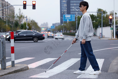 视盲青年使用盲杖探路过马路图片