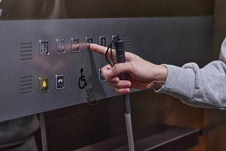 手字体素材视盲青年按电梯特写背景