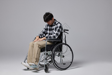 青年男性坐轮椅沮丧形象图片