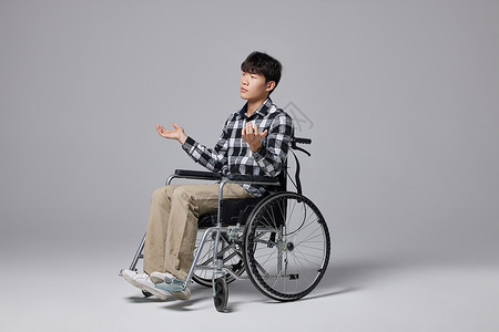 青年男性坐轮椅无奈形象高清图片