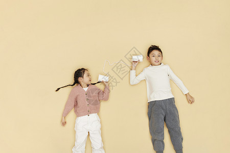 用纸杯传话玩耍的儿童高清图片