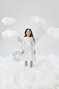 天使在身边戴着天使翅膀的小女孩站在云朵间背景