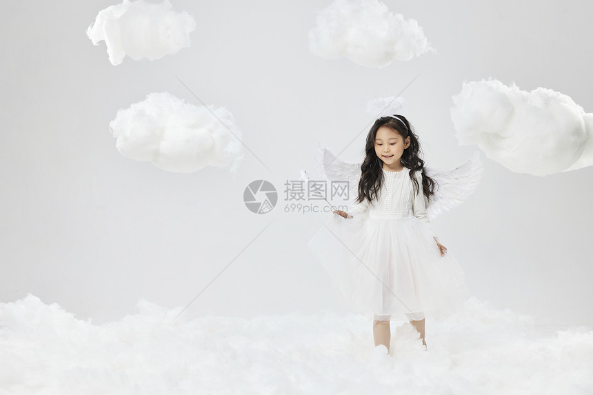 戴着天使翅膀走在云端的可爱小女孩图片