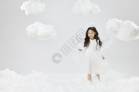 戴翅膀的女孩戴着天使翅膀走在云端的可爱小女孩背景