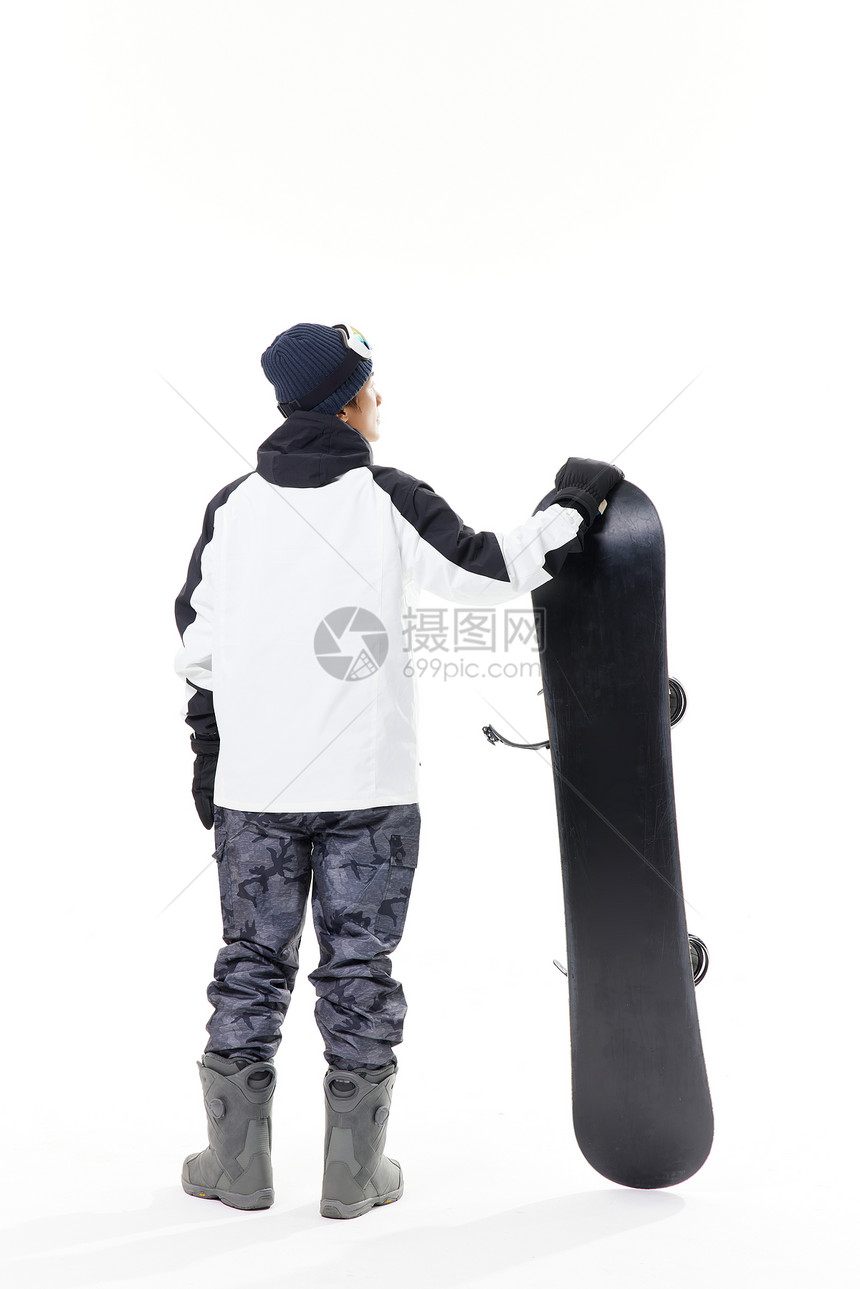 年轻男性拿着滑雪板背影图片