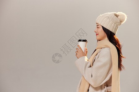 冬季美女拿着咖啡杯暖手图片