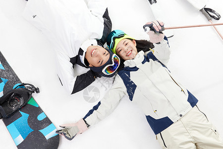 雪女玩滑雪的青年男女躺在雪地上背景