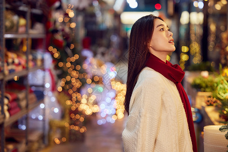 美丽圣诞橱窗集市采购圣诞装饰的青年女性背景