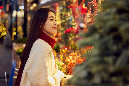 青年女性逛圣诞集市看橱窗背景图片