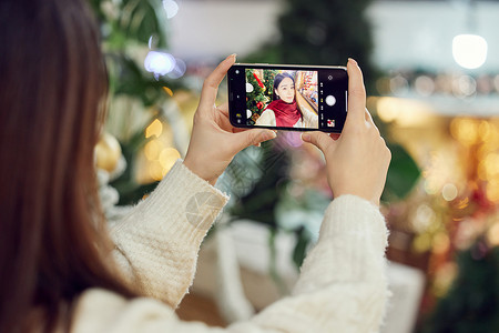青年女性与圣诞树自拍特写背景图片