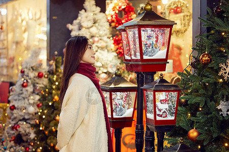冬日美女挑选圣诞氛围灯背景图片