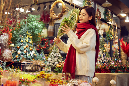 圣诞节花束青年女性在花卉集市上采购花束背景