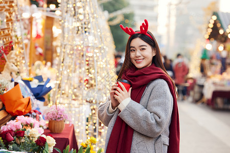 圣诞冬季手捧咖啡的冬日女性逛圣诞市集背景