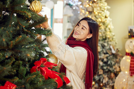 青年女性挂圣诞装饰物背景图片