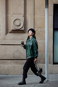 街头时尚女性手拿咖啡图片
