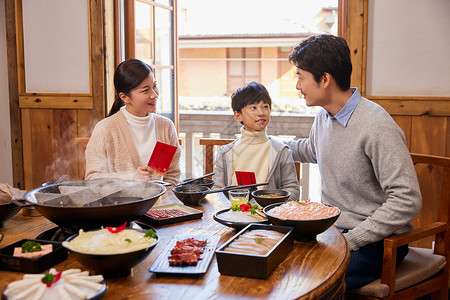 火锅店吃火锅发红包的新年家庭背景图片
