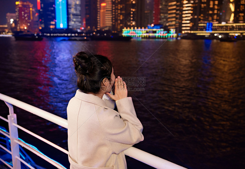 夜晚船上大声呐喊的年轻女性背影图片