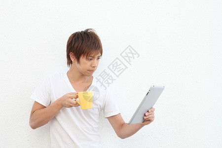 一个人在喝咖啡时使用平板电脑图片