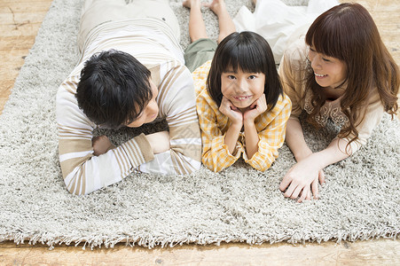 一家人趴在地毯上聊天图片