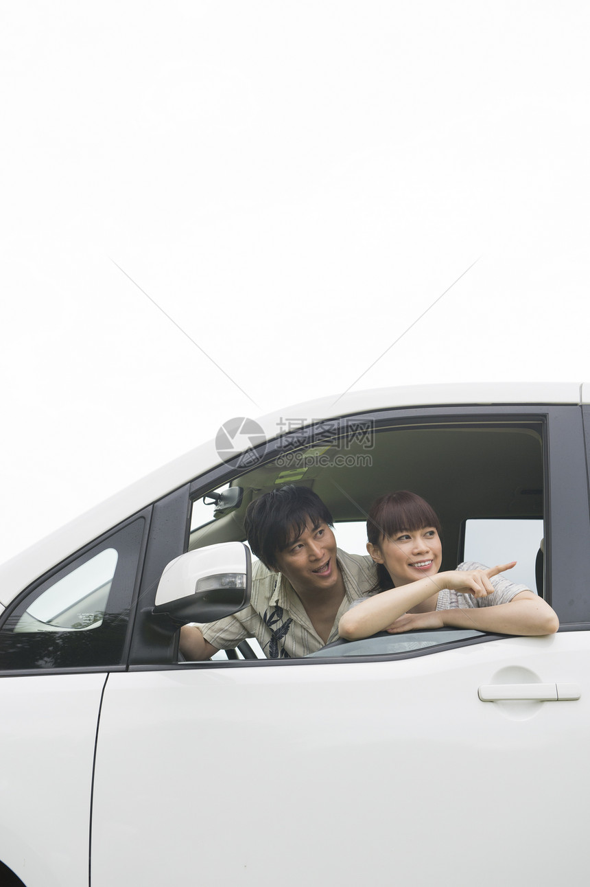 年轻夫妇开着车欣赏美景图片