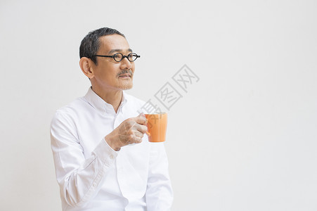 中年男子手拿茶杯喝茶形象图片