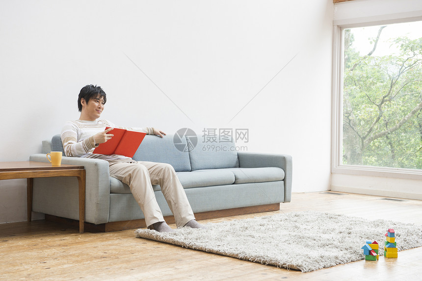 爸爸坐在客厅的沙发上看书图片