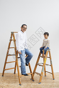 爷爷和孙子坐在装修的梯子上图片
