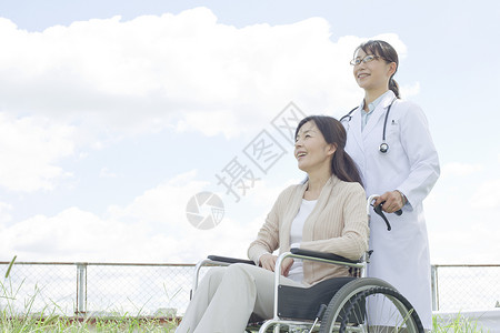 医生推着轮椅上的病人户外散步图片