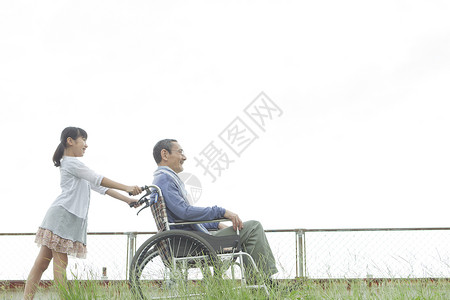 小姑娘推着轮椅上的爷爷图片