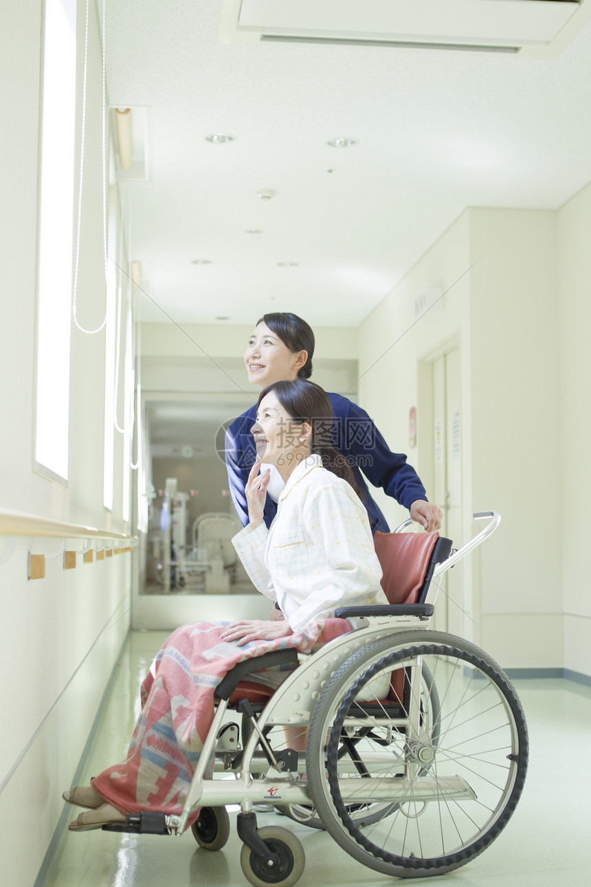 走廊上的护士推着轮椅上的女人图片