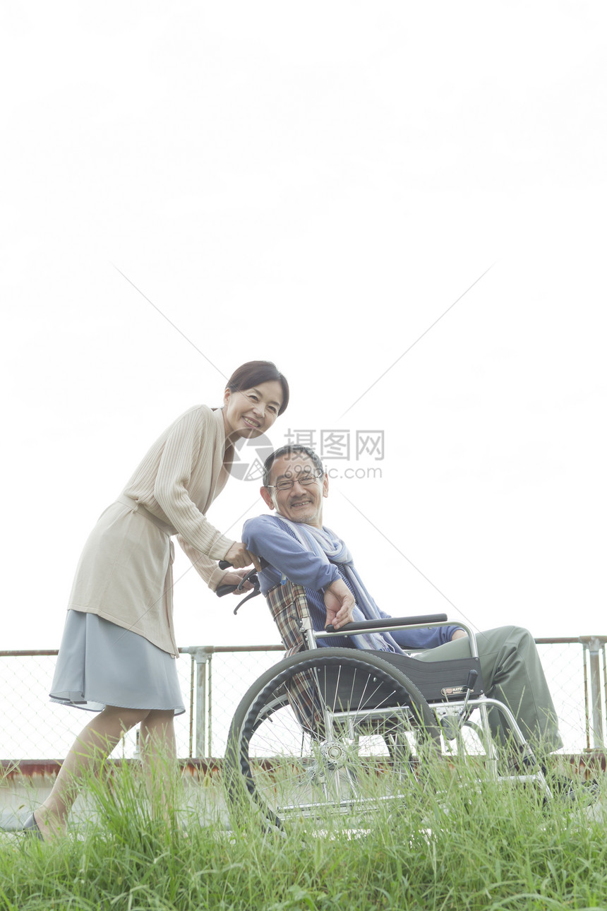 妻子推着轮椅上的丈夫散步图片