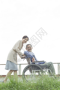 妻子推着轮椅上的丈夫散步图片