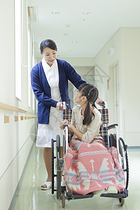 走廊上的护士与轮椅上的小女孩图片