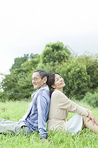 草地上坐着的一对夫妇背景图片