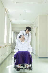 医院走廊上的医生和轮椅上的病患图片