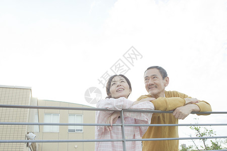 靠在栏杆旁看风景的老年夫妇图片