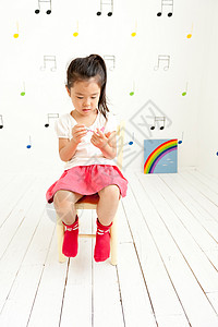 小女孩坐在儿童房里玩耍图片