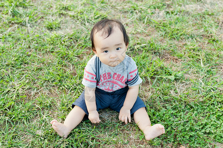 婴儿宝贝坐在公园草地上图片