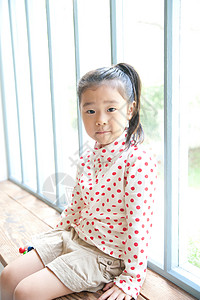 小女孩坐在客厅窗边肖像图片