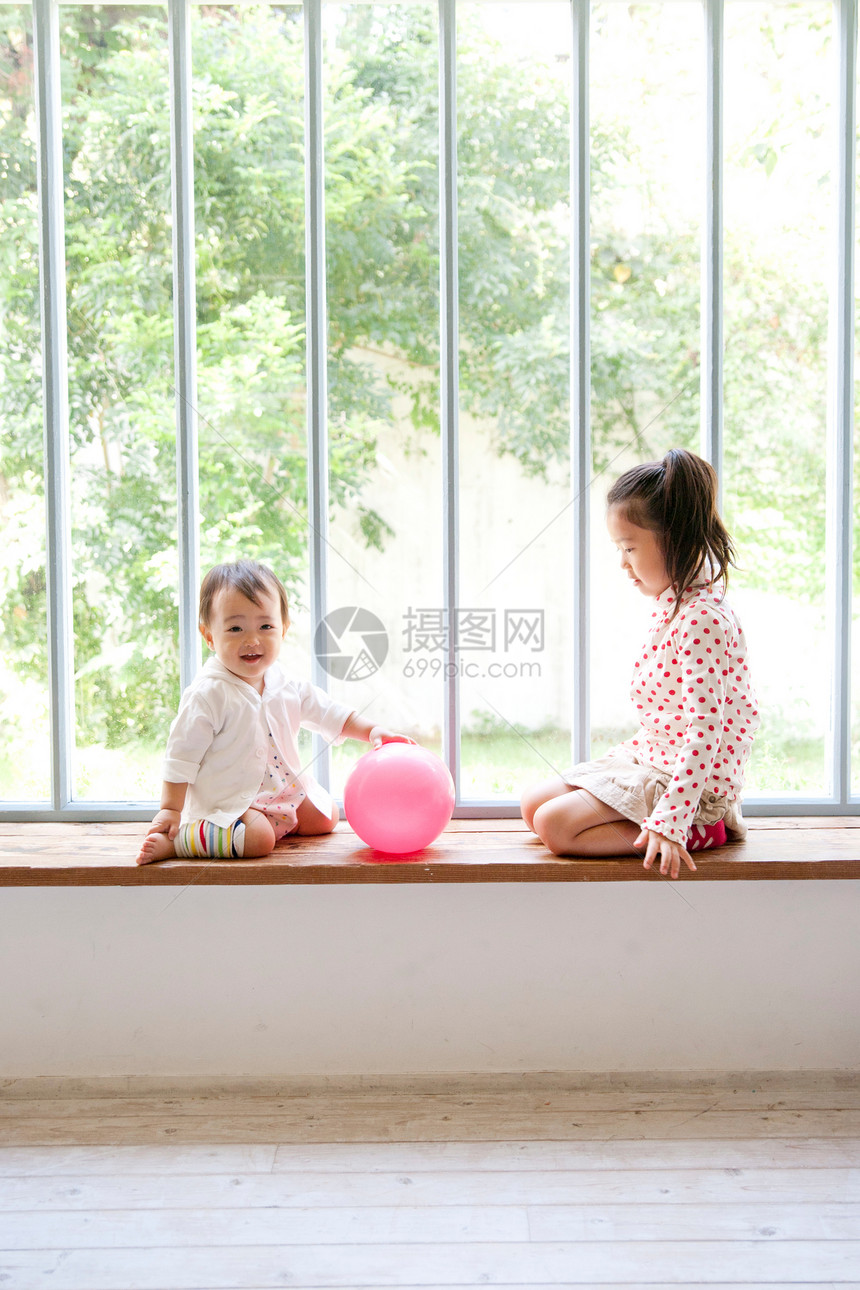 姐弟俩在窗台前玩皮球图片