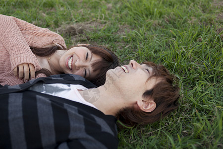 一对夫妇躺在草坪上背景图片
