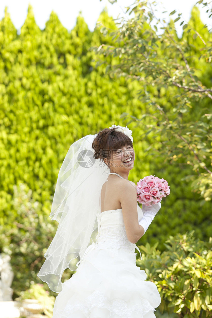 穿婚纱的幸福女人手拿捧花图片