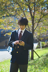 操作智能手机的男高中学生图片