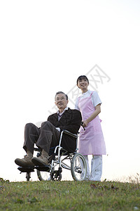 护工推着轮椅上的老爷爷户外散步图片