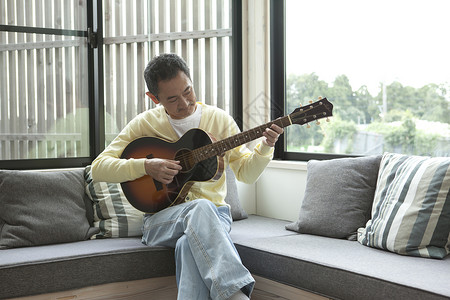 沙发上弹吉他的中老年人图片