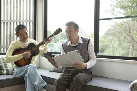 沙发上弹吉他娱乐的老年人图片