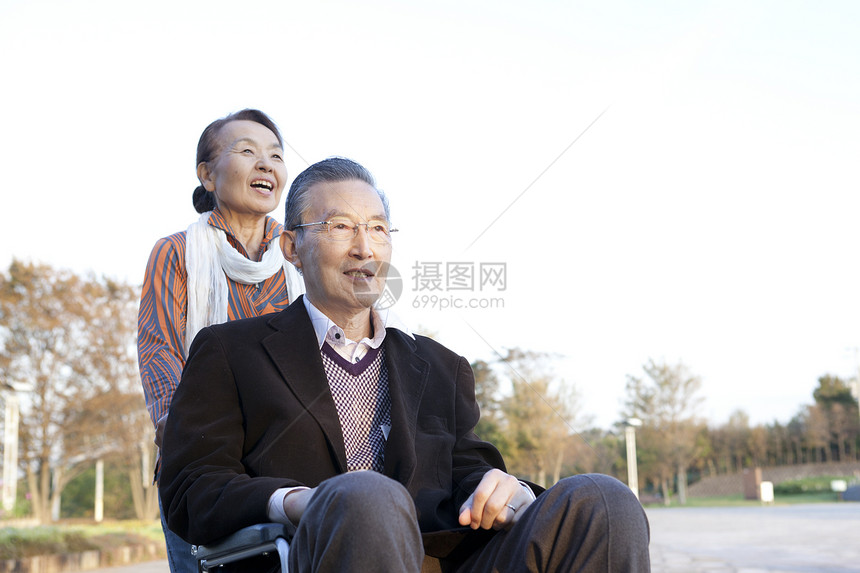 公园里爷爷推着轮椅上的奶奶散步图片