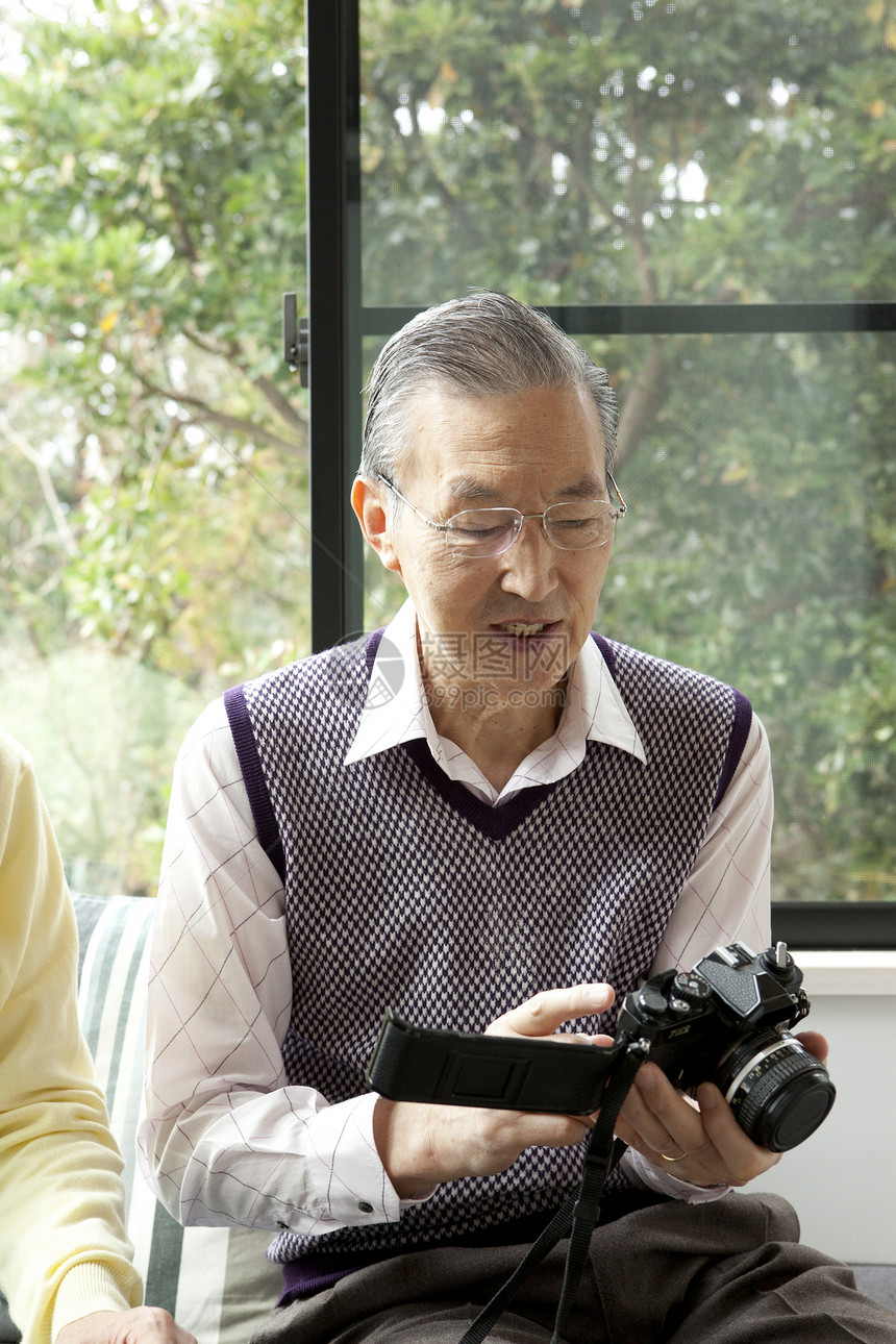 老年男性独自居家研究相机图片