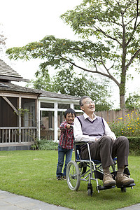 孙子推着轮椅上的老年人后院散步图片